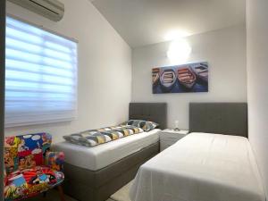 a bedroom with two beds and a chair and a window at Villa Dupini in Baška +39 photos
