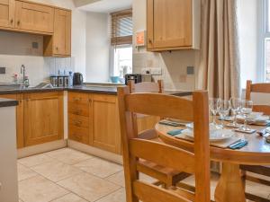 a kitchen with a wooden table and a dining room at Hatters Croft in Cockermouth