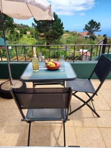 a table with a bowl of fruit and a bottle of wine at Casa Vida Alegre in Prazeres