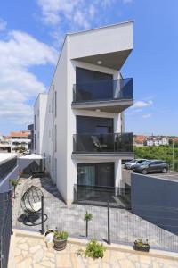Casa blanca con balcón con coche en Apartment Garden, en Zadar