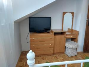 ein Wohnzimmer mit einem TV und einer Kommode mit einer Kommode in der Unterkunft Orange city apartment's Repić in Biograd na Moru