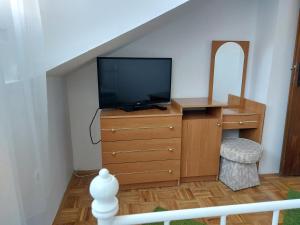 a living room with a tv and a dresser with a dresserngth at Orange city apartment's Repić in Biograd na Moru