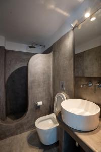 a bathroom with a white sink and a toilet at Liana Studios in Mýkonos City