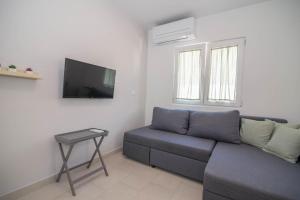 a living room with a couch and a tv at Ivana C6 in Veli Lošinj