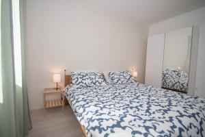 a bedroom with a bed with a blue and white comforter at Ivana C6 in Veli Lošinj