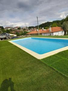a large swimming pool in a grassy yard at Casa das Olmedas in Vimioso