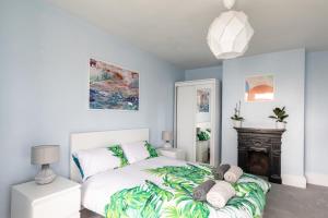 ein Schlafzimmer mit einem weißen Bett und einem Kamin in der Unterkunft Eden Cottage - 9 Guests, Sea Views, Central Cowes, Ferry Deal in Cowes