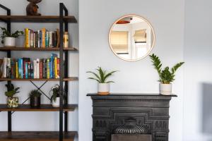 a mirror on a shelf next to a table with plants at Eden Cottage - 9 Guests, Sea Views, Central Cowes in Cowes