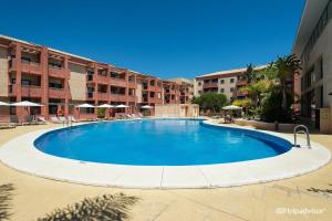 una gran piscina en medio de un edificio en Punta Umbria ideal apartamento Enebrales en Punta Umbría