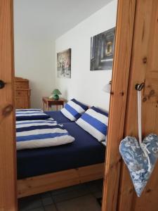 a bedroom with a bed with blue and white striped pillows at Hyggelig in Kosel