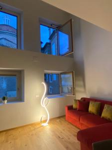 a living room with a red couch and windows at Chic Stay Boutique Apartments in Florence