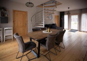 a dining room with a wooden table and chairs at Kempings Ozolkalns in Cēsis