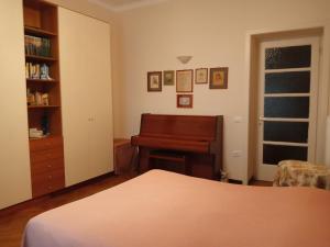 una camera con pianoforte e un letto in una stanza di B&B La Clé a Trieste
