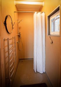 a bathroom with a shower and a shower curtain at Kempings Ozolkalns in Cēsis +37 photos