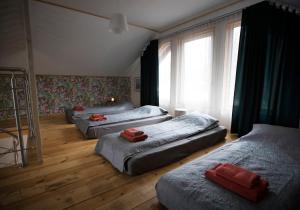 a bedroom with three beds and a window at Kempings Ozolkalns in Cēsis