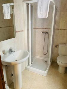 uma casa de banho com um chuveiro, um lavatório e um WC. em Hostal La Serna em Potes
