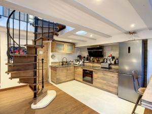 a kitchen with a spiral staircase in the middle at Pygmalion appartement in Avignon