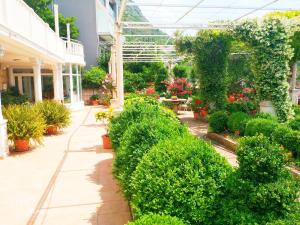 a garden with plants and flowers in a greenhouse at Apartments & Rooms Čakelić in Mlini