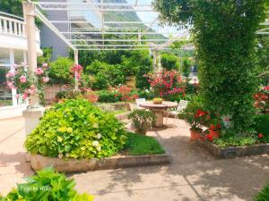 a garden with flowers and a table in a greenhouse at Apartments & Rooms Čakelić in Mlini