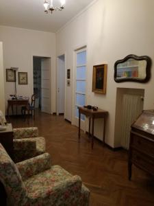 a living room with a chair and a table and a mirror at B&B La Clé in Trieste