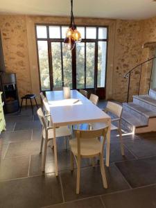 uma sala de jantar com uma mesa branca e cadeiras em Mas Saint-Ferdinand - maison avec piscine em La Capelle-et-Masmolène