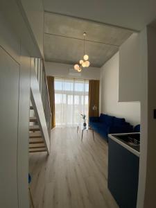a kitchen and a living room with a blue couch at Apartament Wrocław-Lotnisko in Wrocław