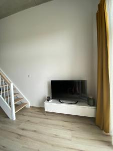 uma sala de estar com uma televisão de ecrã plano num armário branco em Apartament Wrocław-Lotnisko em Breslávia