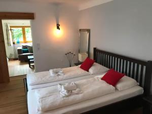 two beds in a room with red and white pillows at AlpinCreek in Leogang +21 photos
