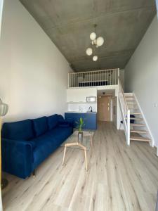 a living room with a blue couch and a staircase at Apartament Wrocław-Lotnisko in Wrocław