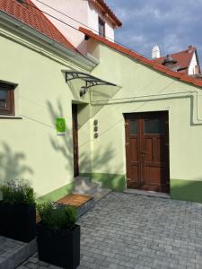 een wit huis met een bruine deur en een trap bij FLH - Limette Home in Sibiu