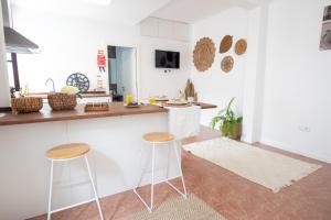 a kitchen with two bar stools and a counter at The Village House in Machico