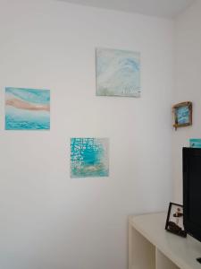 uma sala de estar com três pinturas na parede em Ocean em Orio