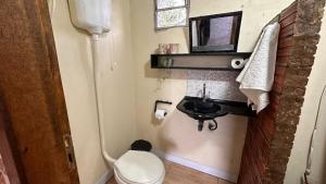 a small bathroom with a toilet and a sink at Amorada in Santo Amaro
