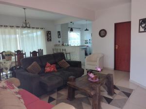 a living room with a black couch and a table at Casa em Penedo RJ in Penedo