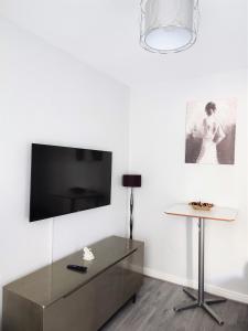 a living room with a tv and a table at havilahomes in Manchester