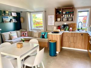 a kitchen and living room with a couch and a table at Mobil Home excellence 6 personnes au camping Siblu Mer et Soleil, Saint George d'Oléron in Les Sables Vignier