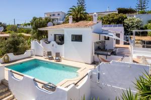 eine Villa mit einem Pool und einem Haus in der Unterkunft CoolHouses Algarve, Luz, 3 Bed villa, 1 bed studio, heated pool & jacuzzi, sea views, Casa Pequena in Luz