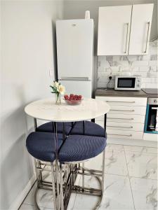 a kitchen with a white table and two blue chairs at havilahomes in Manchester