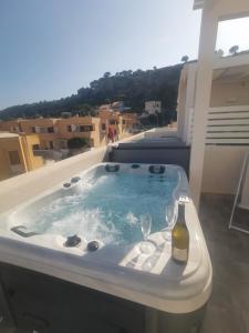 a hot tub with two glasses and a bottle of wine at MARE e Terra Holiday fronte mare in San Vito lo Capo