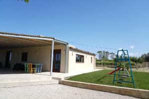 un parque infantil con un tobogán en un patio en le casette, en Aradeo