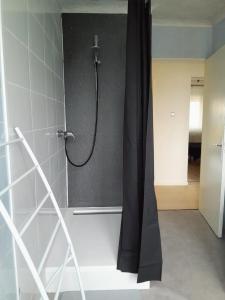 a shower with a black shower curtain in a bathroom at Eden in Créhange