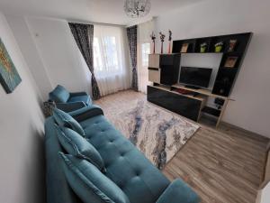 a living room with a blue couch and a television at Apartament Holiday in Mamaia Nord