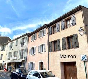 a building on a street with cars parked in front of it at Maison de village chez Audrey in Ramatuelle