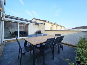 a wooden table and chairs on a patio at Royal Terrace - Maison plage & Parking privé in Dunkerque