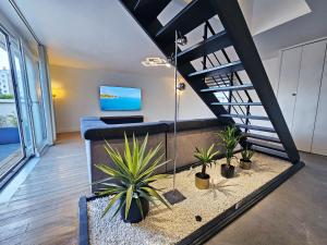 un salon avec un escalier et des plantes en pot dans l'établissement Royal Terrace - Maison plage & Parking privé, à Dunkerque