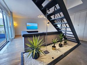a living room with a staircase and potted plants at Royal Terrace - Maison plage & Parking privé in Dunkerque