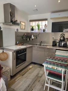 cocina con electrodomésticos de acero inoxidable y suelo de madera en Studio Cosy" La Cigale", en Fréjus 4 fotos más