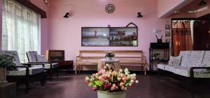 CHARAKAMA Guest Bungalow - GAMPAHA في غامباها: صالون فيه كراسي وزهور في الغرفة