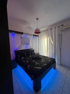 Un dormitorio con una cama negra con luces azules en Ελένη, en Megalochori