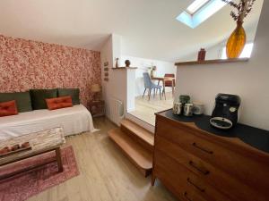 a bedroom with a bed and a dresser and a kitchen at Le clos des grandes rivières in Sainte-Soulle